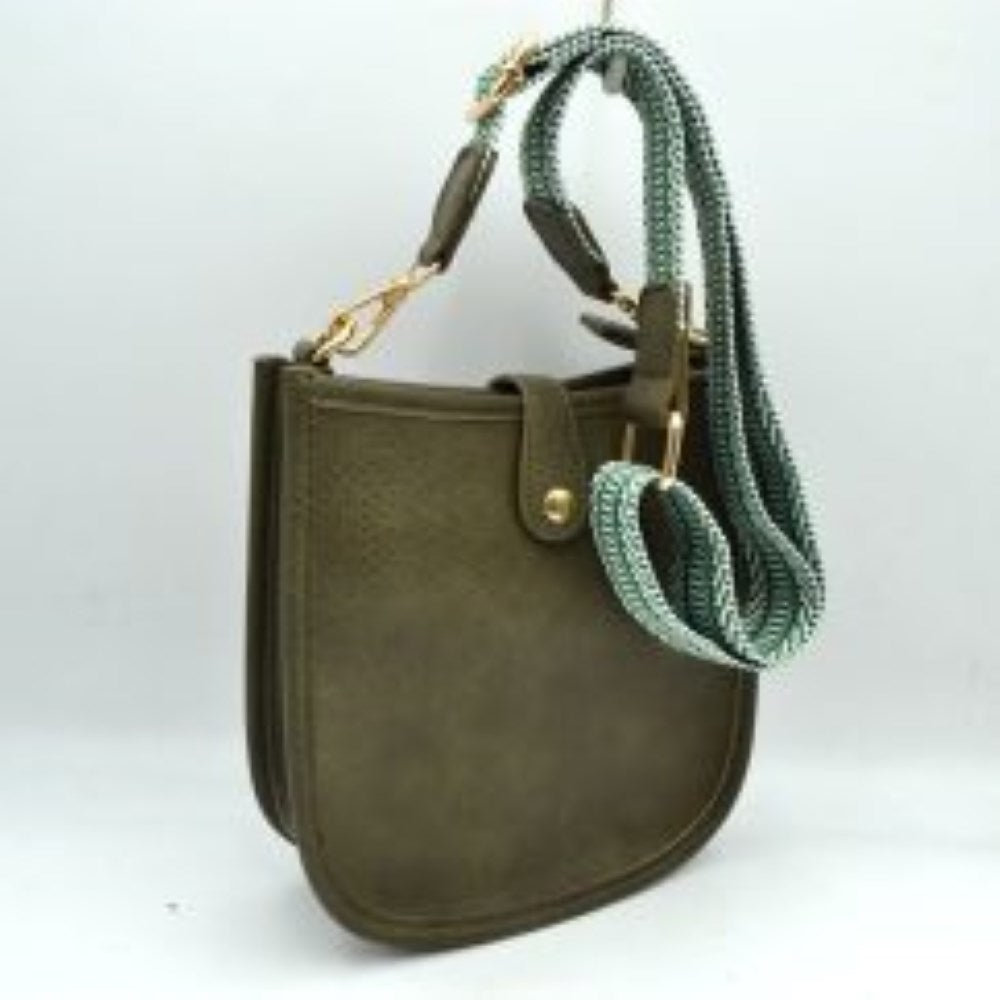 Dark green This stylish crossbody bag presents a clean, minimalist design with a smooth exterior finish and a distinct curved, U-shaped silhouette perfect for everyday use. It features an open top main compartment equipped with a small secure tab closure that fastens at the front with a metallic snap button. Adding a striking contrast, the bag is paired with a thick, adjustable fabric strap showcasing a bold geometric pattern