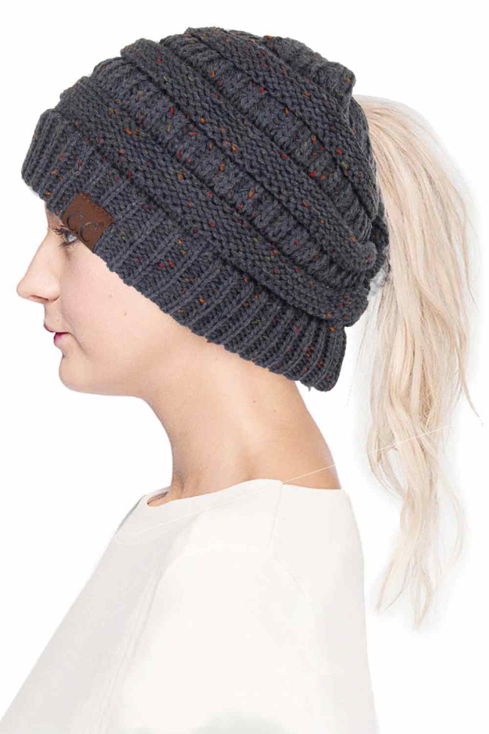 Dark Grey The C.C Confetti Ponytail Messy Bun Beanie features a soft knit design with subtle confetti flecks for a fun, playful look. Designed with a convenient opening for ponytails or messy buns, it keeps you warm while allowing you to style your hair comfortably.