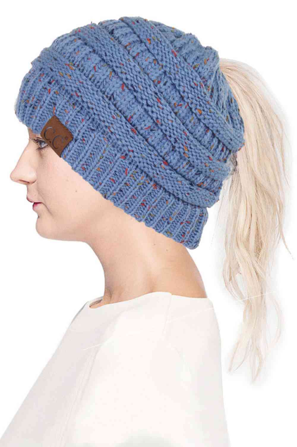 Denim The C.C Confetti Ponytail Messy Bun Beanie features a soft knit design with subtle confetti flecks for a fun, playful look. Designed with a convenient opening for ponytails or messy buns, it keeps you warm while allowing you to style your hair comfortably.