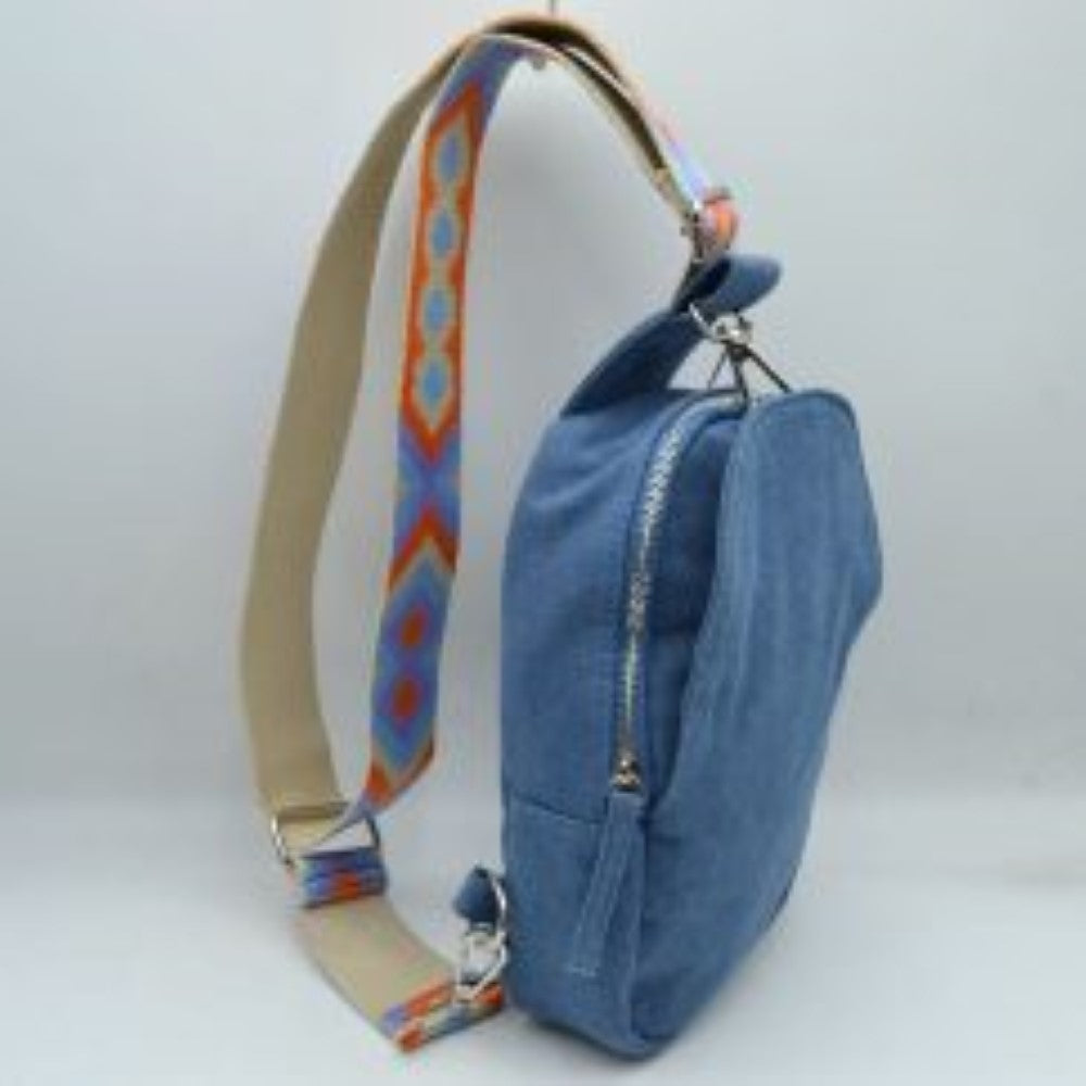 Denim This functional sling bag features a structured silhouette with multiple storage compartments, including a secure zippered main section and an integrated front pocket for easy access to essentials. Perfect for everyday hands-free use, the bag is equipped with a wide, adjustable shoulder strap showcasing an intricate geometric woven pattern. Durable metal hardware and secure clasps connect the strap to the body of the bag, combining practical utility with a casual, modern design.