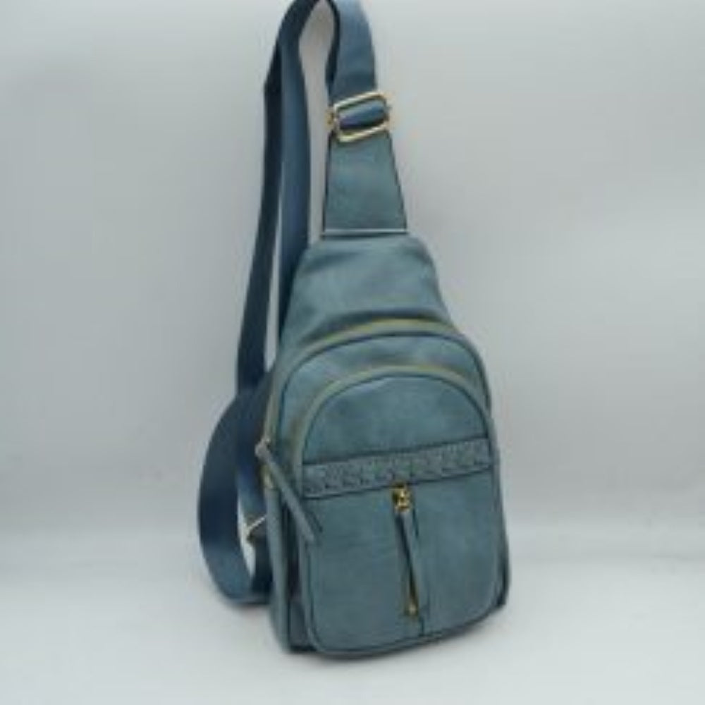 Denim This versatile sling bag features a textured, subtly crinkled exterior with an asymmetric, tiered silhouette ideal for active everyday use. It offers multiple organized storage compartments, including a spacious curved main section, an intermediate arched pouch, and a front pocket highlighted by a horizontal woven, braided strip detail above a vertical zipper track. The bag is completed by a single wide fabric shoulder strap