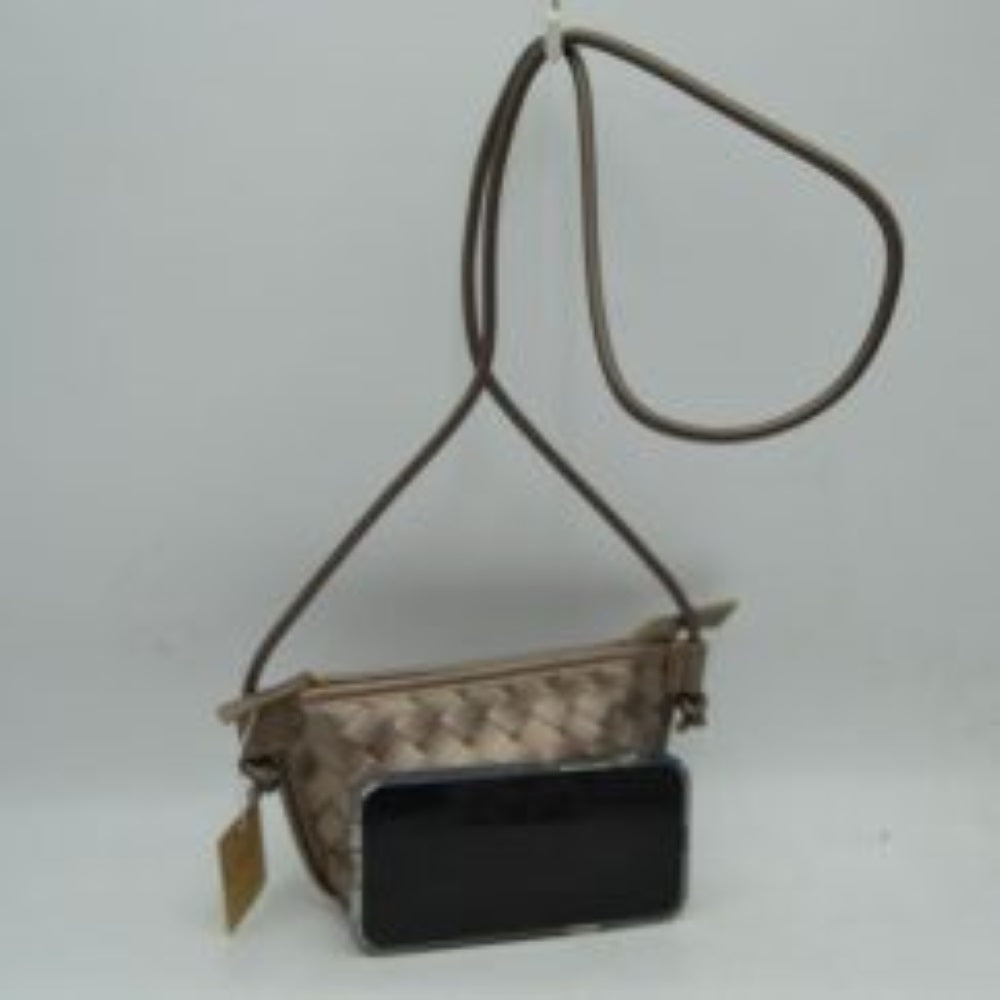 Desart Sand This small crossbody bag features a distinct woven texture across the main body, providing visual interest. A slim, round cord strap, attached with unique knot details, enables comfortable everyday wear. The compact design secures with a top zipper closure, complete with a practical zipper pull, keeping essentials safe and easily accessible within the main compartment.