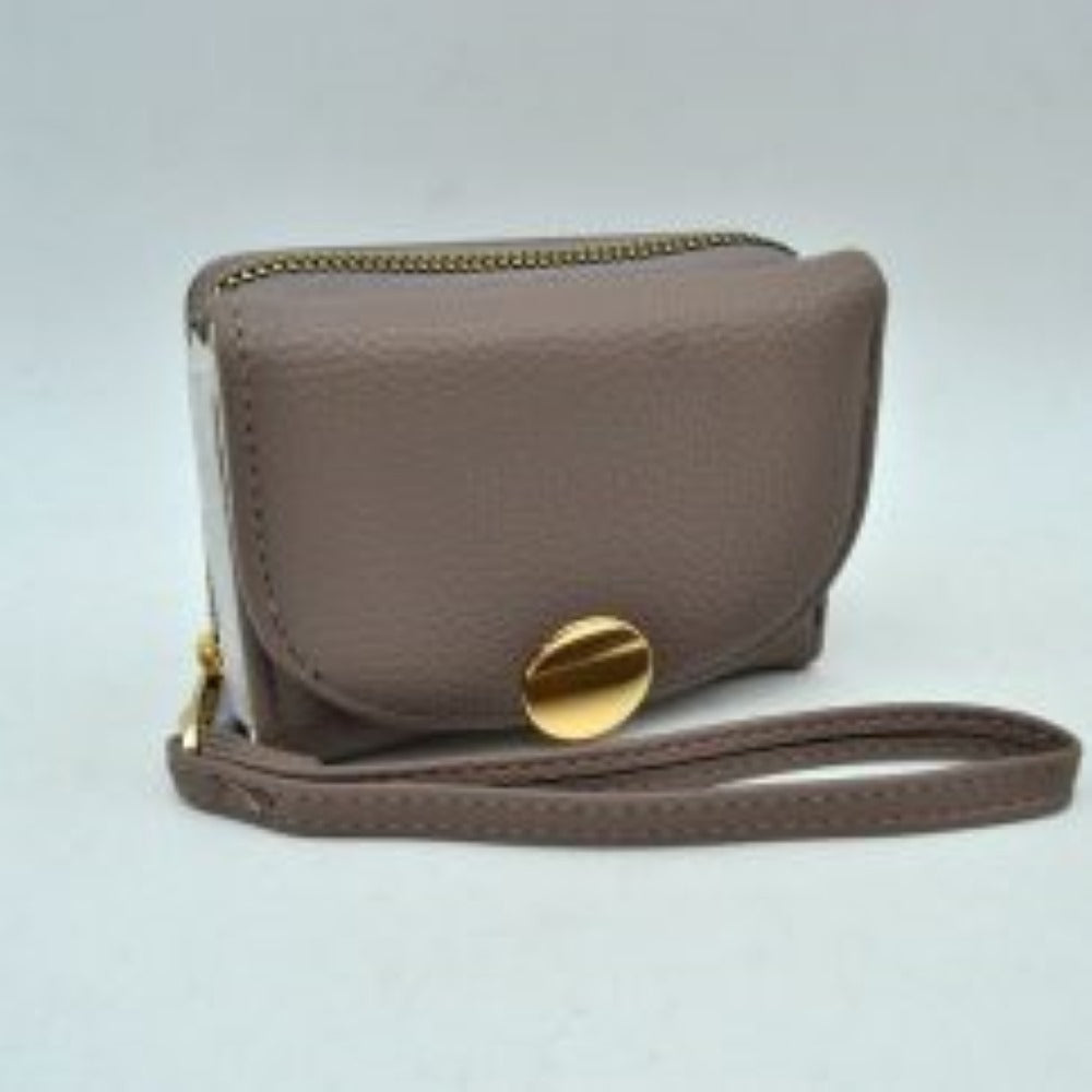 Dusty This compact everyday wallet features a pebbled, textured exterior designed for practical multi-compartment storage. It includes a secure, top zip-around section with metallic teeth alongside a front fold-over flap portion accented by a prominent round metallic button closure. For convenient carrying during daily errands, it comes equipped with a slim, matching wristlet strap attached to the side hardware.