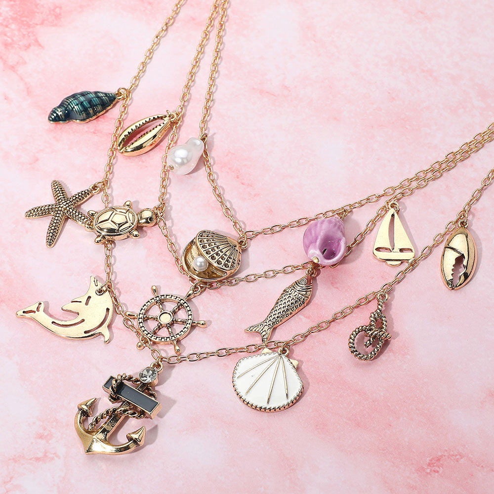 Madeline Love Antique Gold, Multi Anchor Sea Shell Pearl Dolphin Fish Rope Sea Turtle Charm Embellished Triple Layered Necklace - Necklaces