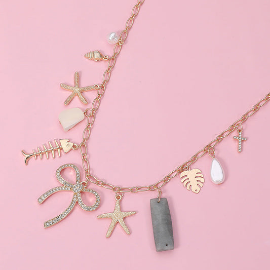 Madeline Love Clear, Gold Stone Paved Bow Metal Starfish Fish Shell Pearl Tropical Leaf Charm Station Necklace - Necklaces