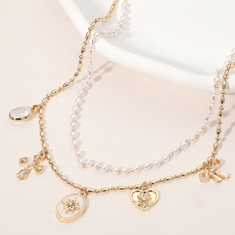 Madeline Love Cream, Gold Cross Floral Heart Bow Charm Station Pearl Layered Necklace