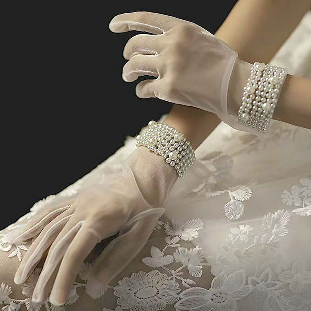 White Refined gloves adorned with clustered pearl accents at the cuff, ideal for formal events, bridal wear, or vintage-inspired looks. These elegant accessories provide a sophisticated finish to your outfit.