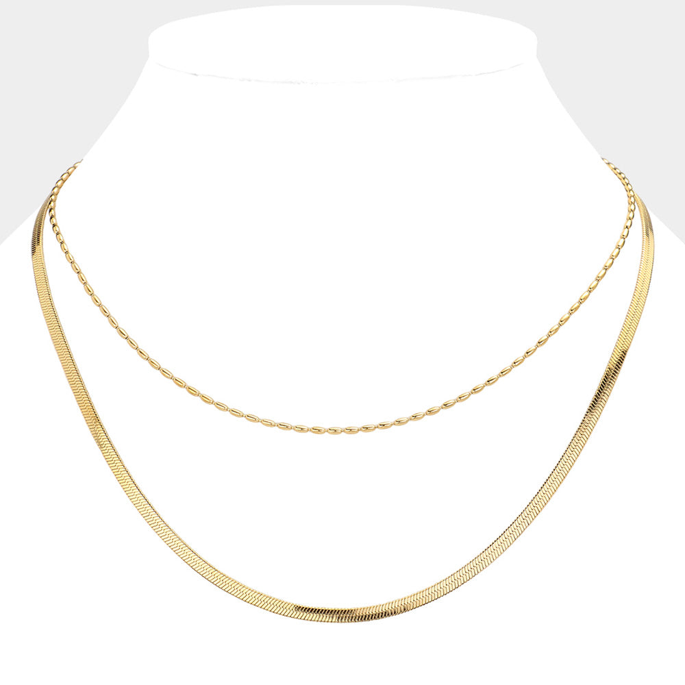 Gold Stainless Steel Herringbone Chain Layered Necklace offers a sleek and stylish addition to any outfit. Crafted from high-quality stainless steel, this necklace is durable and resistant to tarnishing. Its herringbone chain design adds a unique touch, making it a versatile piece for any occasion. Elevate your look with this modern and sophisticated accessory.