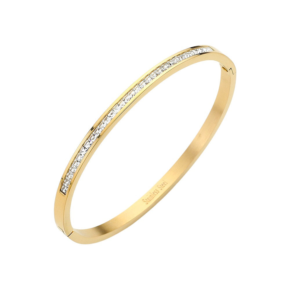 Gold Stainless Steel Rhinestone Paved Hinged Bangle Bracelet is durable and stylish for any occasion. Featuring a sleek stainless steel design and sparkling rhinestone accents, this hinged bangle is perfect for adding a touch of elegance to any outfit. With its sturdy construction and eye-catching design, this bracelet is a must-have for any fashion-forward individual.