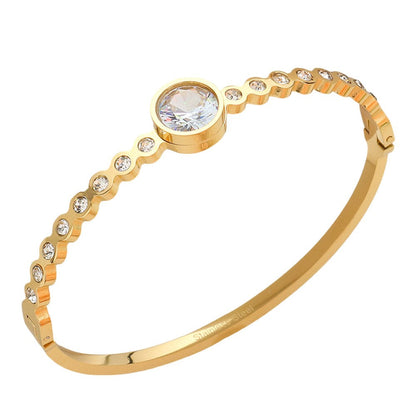 Gold Stainless Steel Round CZ Stone Bezel Hinged Bangle Bracelet. Made with high-quality stainless steel and featuring beautifully cut CZ stones in a bezel setting, this bangle adds a touch of elegance to any outfit. With a hinged design, it is easy to put on and take off for a comfortable fit. Elevate your style with this sophisticated accessory.