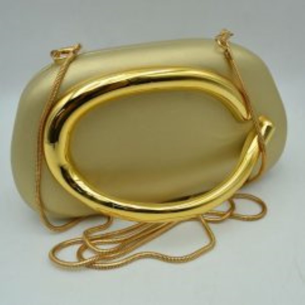 Gold This structured, hard shell clutch bag functions as an elegant accessory for everyday use or special occasions, featuring a smooth matte surface. A large, prominent metallic ring handle anchors the front design, offering a secure hand-held grip. For alternative carrying styles, the bag is equipped with a detachable metallic snake chain strap that secures to the top corners with lobster claw clasps, providing functional storage in a compact, rigid silhouette.