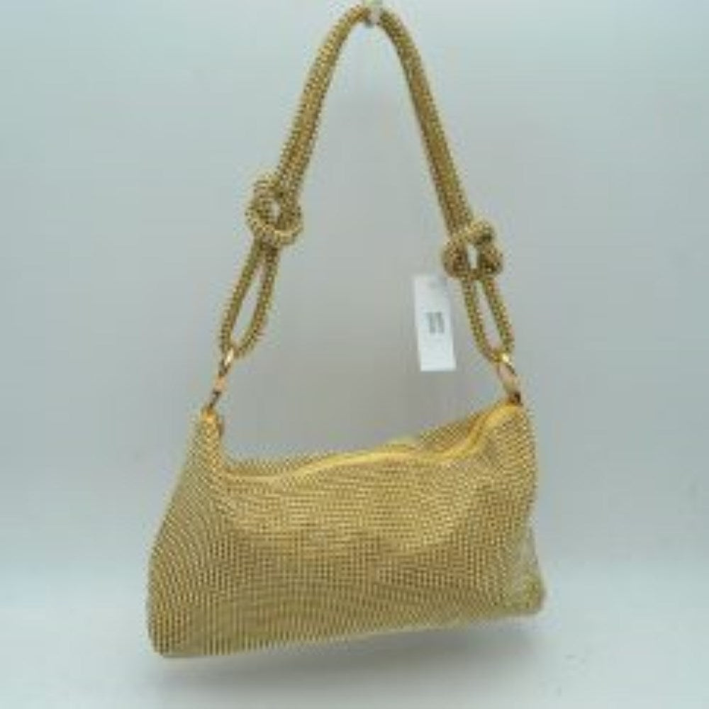Gold This shoulder bag features a textured grid exterior suitable for versatile everyday use. It includes a main storage compartment accessible via a top zipper closure to keep personal items secure. The bag is completed by a matching textured shoulder strap that features integrated decorative knots on each side and connects to the main body through circular rings.