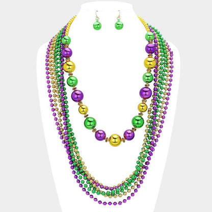 Gold Mardi Gras Ball Beaded Layered Necklace is expertly crafted to deliver a festive and elegant look. Featuring vibrant beads and a stylish layered design, it brings a playful touch to any outfit. Perfect for Mardi Gras celebrations, this necklace is a must-have for party-goers seeking standout accessories.