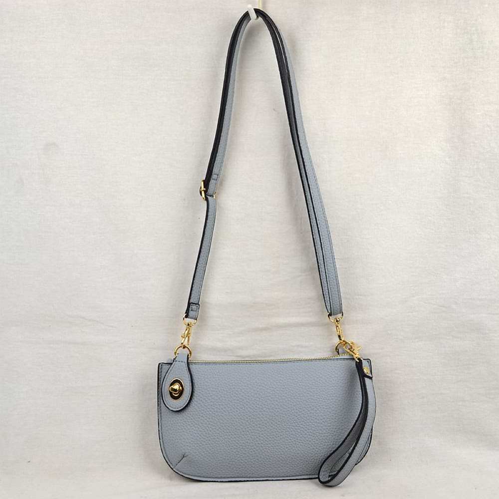 Gray This versatile everyday bag features a compact pebbled textured body with a slightly curved base silhouette. Designed for organized daily or evening use, the main storage compartment is secured by a top zipper closure and accented with a small decorative metallic turn-lock detail on the side panel. It offers multiple carrying options, equipped with a long, adjustable crossbody shoulder strap and a shorter matching wristlet loop