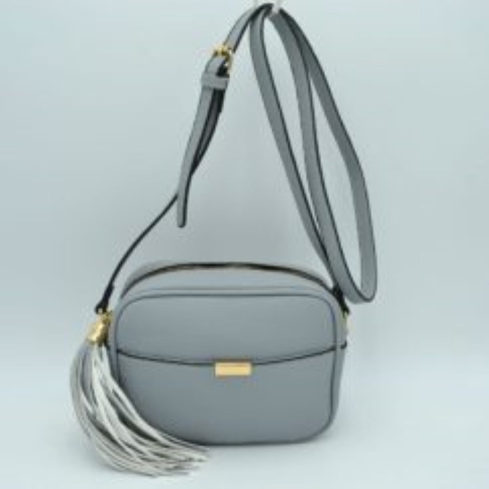 Gray This sophisticated crossbody bag features a structured camera-bag silhouette crafted from a textured pebbled faux leather in a neutral beige tone, making it a versatile addition to any wardrobe. The clean-lined front is detailed with a subtle open slip pocket highlighted by a polished, gold-tone metal hardware accent at the center. Secured by a smooth top-zipper closure, the bag is finished with an adjustable shoulder strap and a dramatic