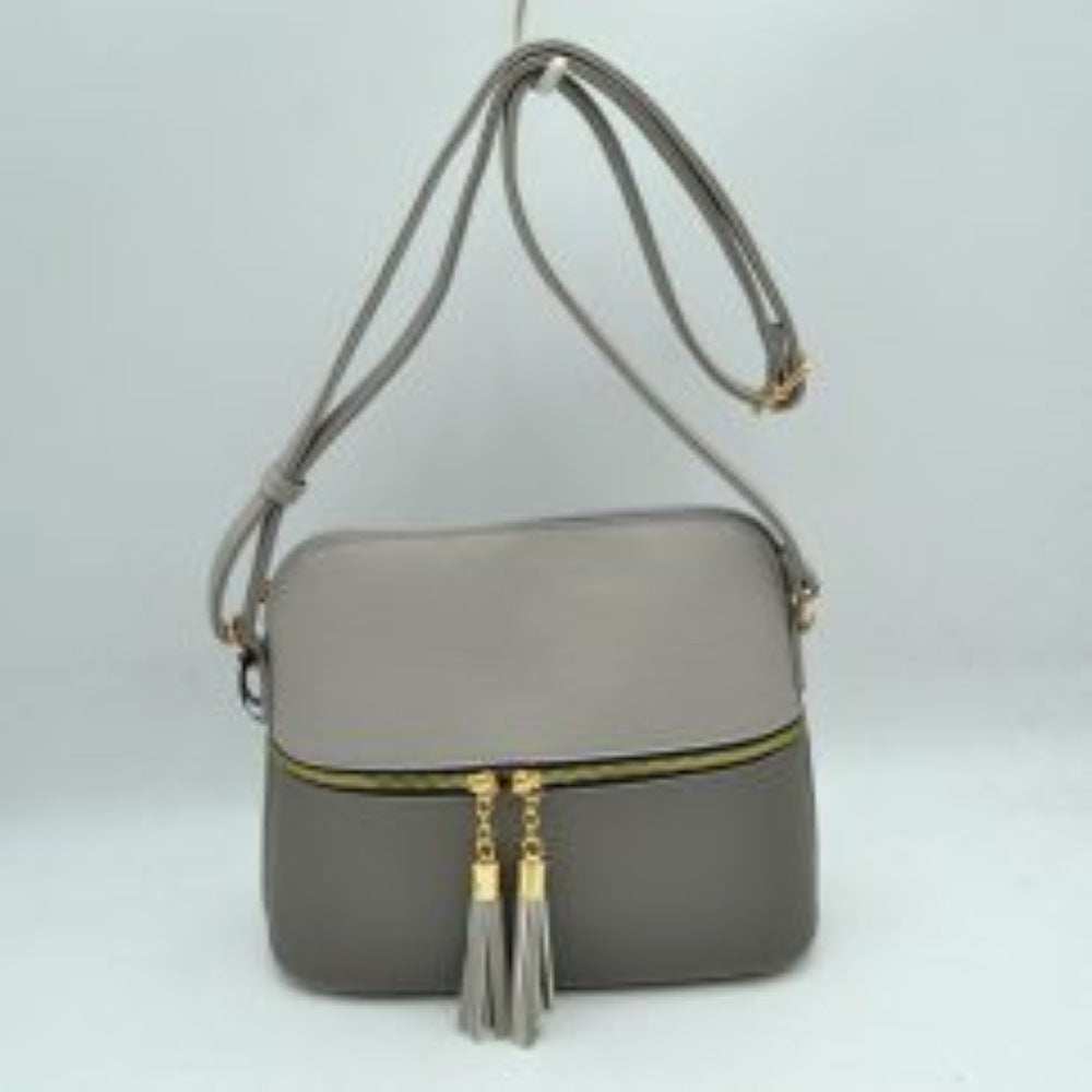 Gray This everyday crossbody bag features a structured pebbled texture body with a distinct two-toned paneled design. Ideal for organized daily use, it showcases a prominent horizontal front zipper with dual gold-toned pulls, each adorned with a decorative hanging fringe tassel. The main storage compartment is paired with a matching long
