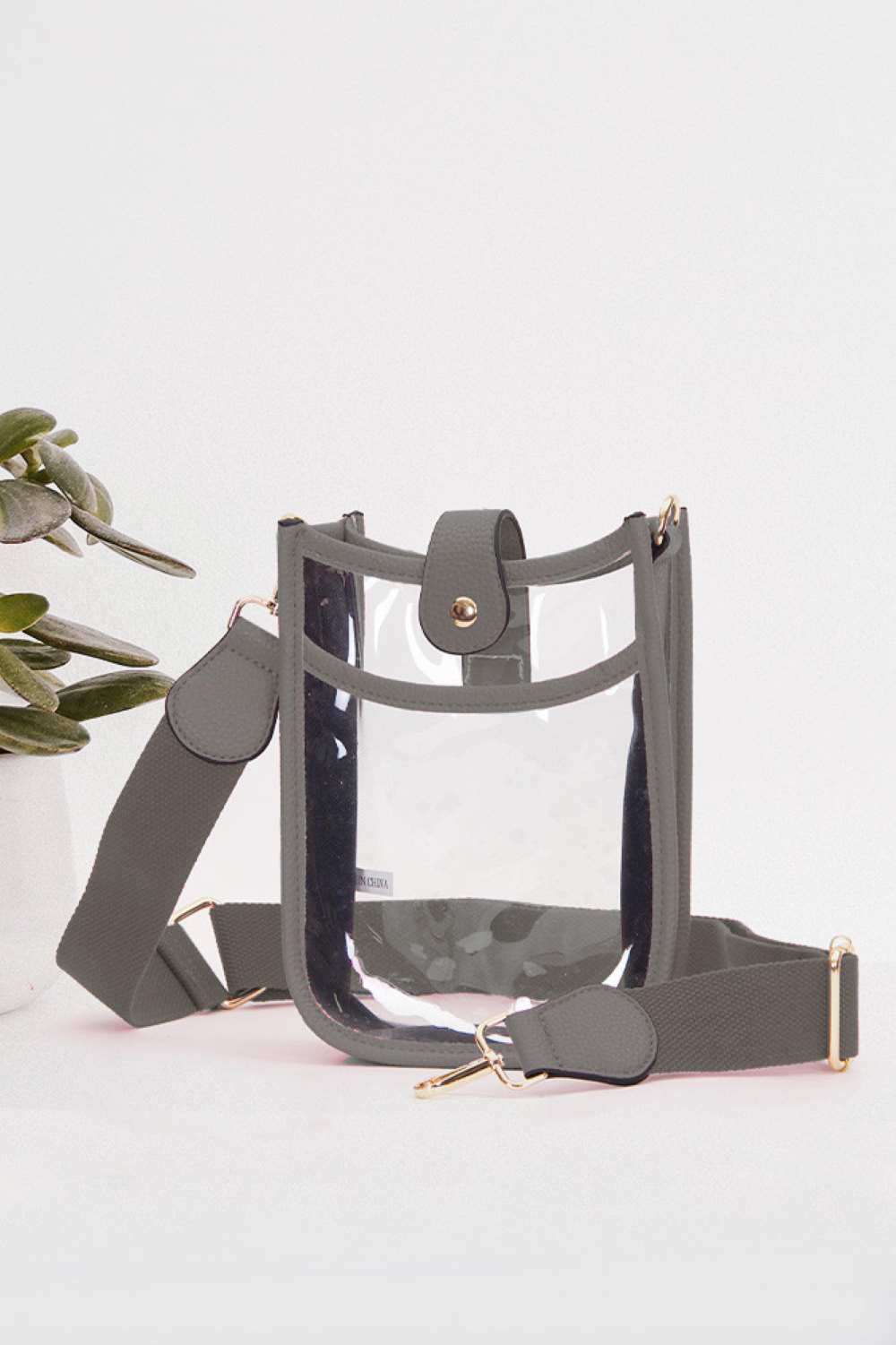 Gray Perfect for concert season and stadium events, this clear crossbody mini bag meets all venue security requirements while keeping your essentials within reach. Crafted from durable 100% PVC, it's easy to clean and built to last through countless outings. Compact yet functional at 8" x 5.8" x 2.3", the adjustable crossbody strap sits comfortably across your body, leaving your hands free. The transparent design lets you quickly locate your phone, keys, and small valuables at a glance.