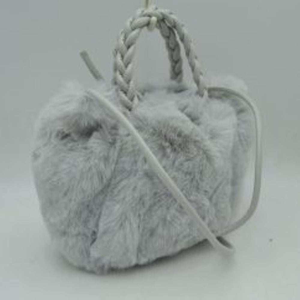 Gray This soft everyday bucket-style handbag features a densely textured, plush exterior that offers a cozy aesthetic for daily use. Designed with a structured yet flexible silhouette, it features dual braided top handles for comfortable hand carrying alongside a slender, long shoulder strap that provides hands-free convenience. The top opening reveals a spacious central storage compartment ideal for organizing essential items