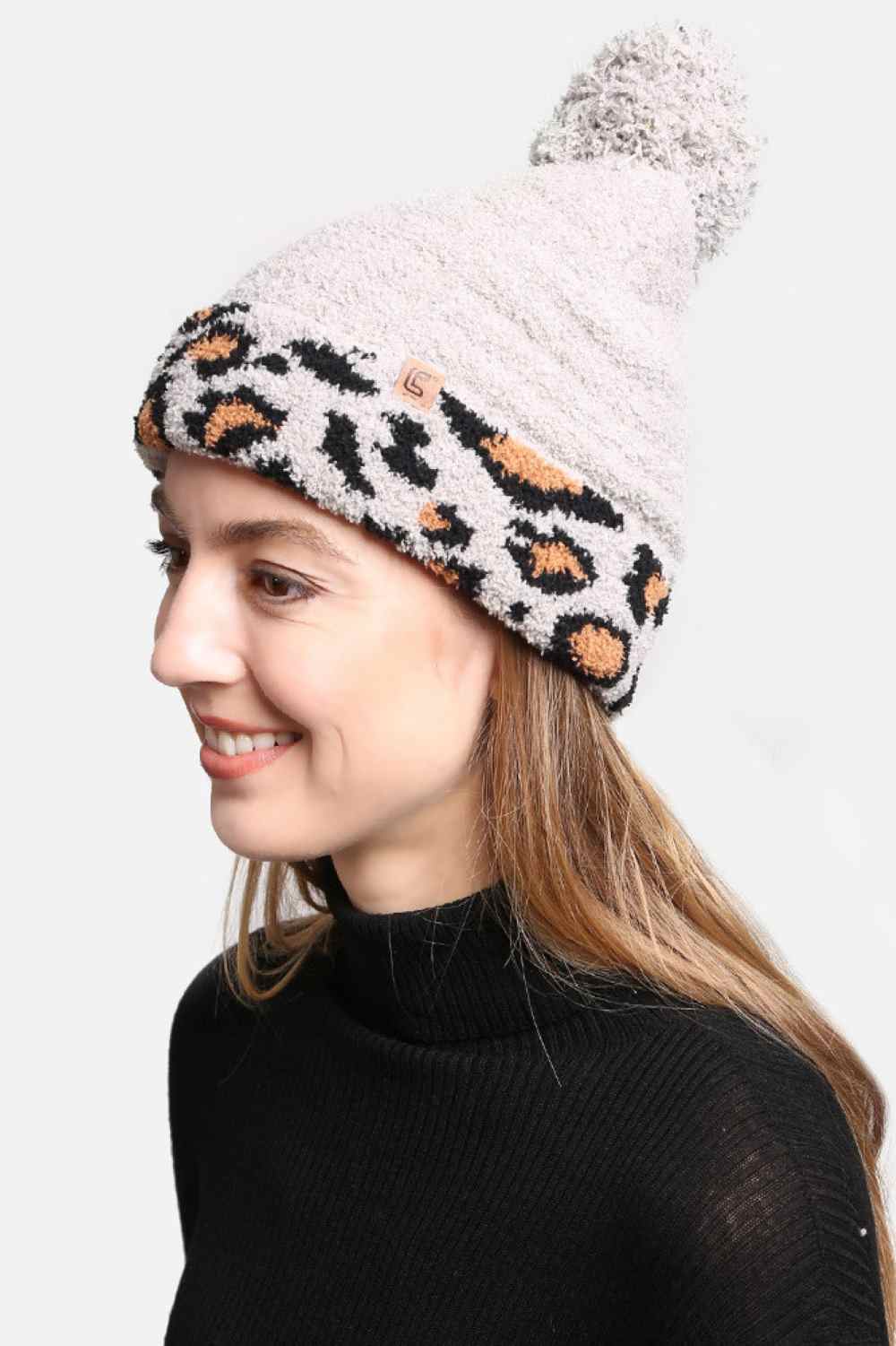 Gray The Leopard Cuffed Pom Pom Lining Beanie features a trendy animal print design with a stylish cuffed finish for a bold winter look. Crafted with a soft inner lining and topped with a fluffy pom pom, it delivers extra warmth, comfort, and a snug fit for chilly days.
