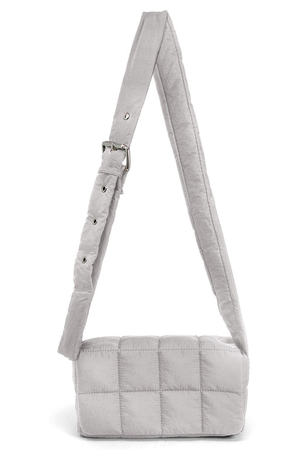 Gray Compact quilted puffer crossbody bag with a sleek, modern design. Measures 8.7" x 4.7" with a 2.4" depth, perfect for carrying essentials while keeping your hands free. The padded construction offers durability and a soft touch. Ideal for everyday outings, travel, or casual errands.