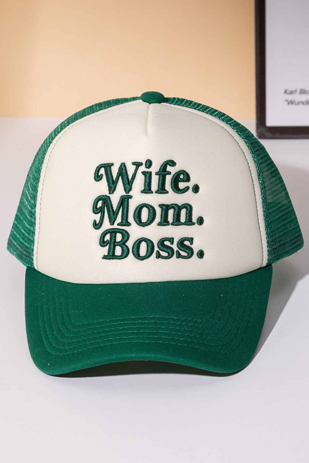 Green Perfect for the multitasking woman who does it all. This trucker cap features bold "WIFE MOM BOSS" lettering on a structured foam front with breathable mesh back paneling. The snapback closure ensures a comfortable, adjustable fit for any head size. Made from 100% polyester for durability and easy care. Whether you're heading to work, running errands, or just making a statement, this cap celebrates your hustle with style and attitude.