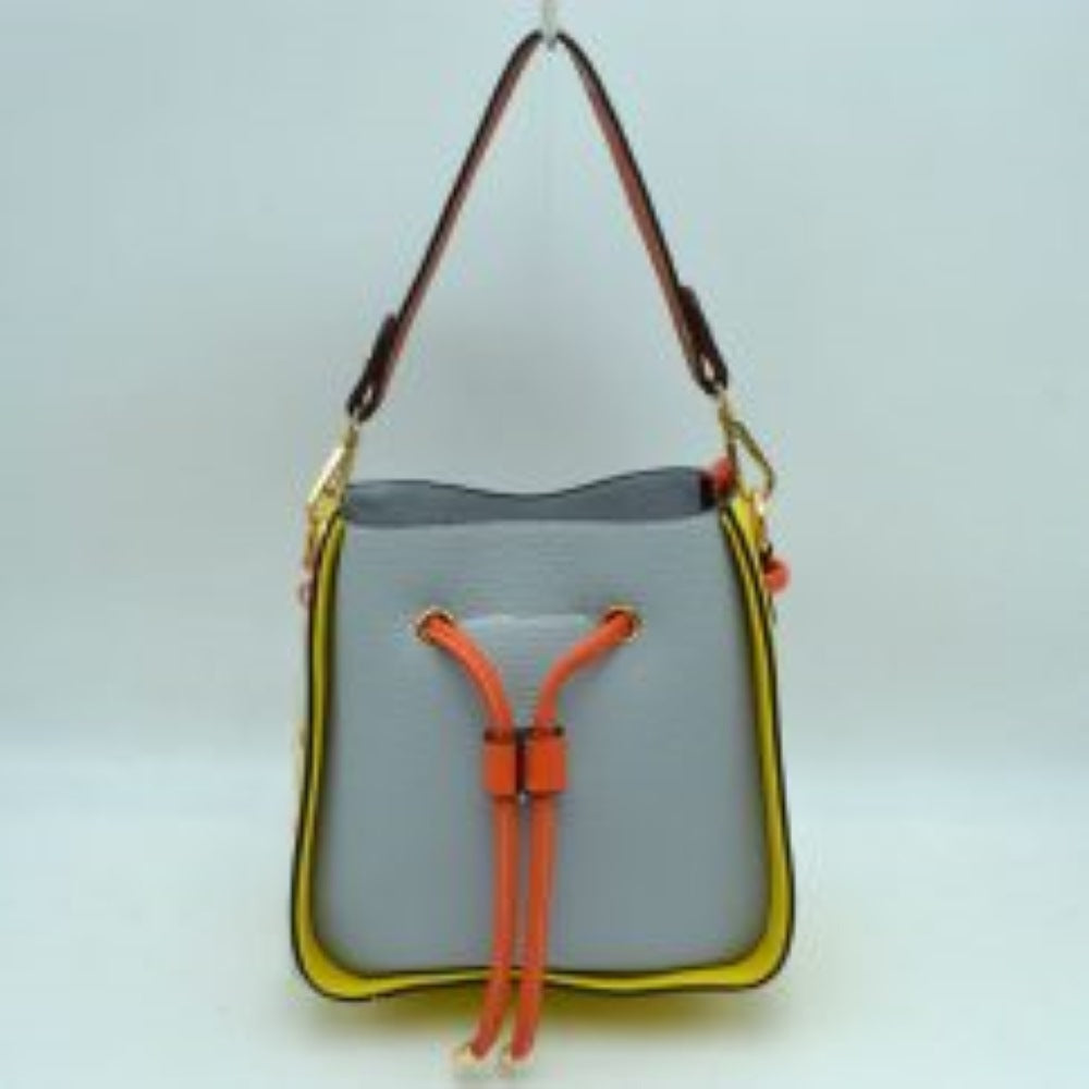 Grey This stylish bucket bag features a distinctive color-blocked design crafted with a pebbled exterior texture, making it a versatile accessory for everyday use. The front panel includes a classic cinch drawstring closure detailed with contrasting trim and polished metallic aglets that open to a secure main storage compartment. Built for flexibility, it is equipped with a structured shoulder handle, an adjustable long shoulder strap