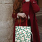 Reusable Christmas tote bag featuring a festive holly and berry print. Ideal for holiday shopping, gifting, or seasonal outings. Durable and stylish, it's a cheerful addition to your holiday essentials.