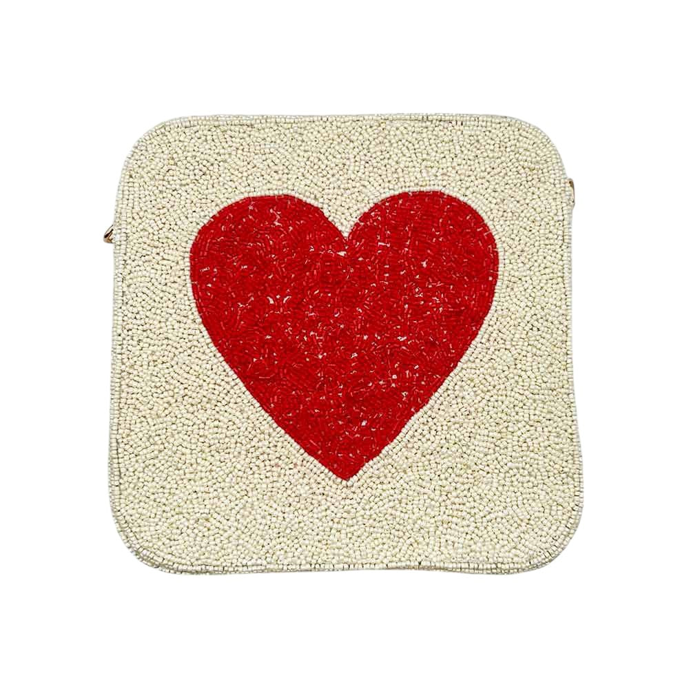 Ivory Heart accented crossbody bag is adorned with delicate seed beads, adding a touch of elegance to any outfit. The compact square shape is perfect for carrying your essentials, while the crossbody strap keeps your hands free. The unique design and quality materials make it a must-have accessory for any fashion-forward individual.