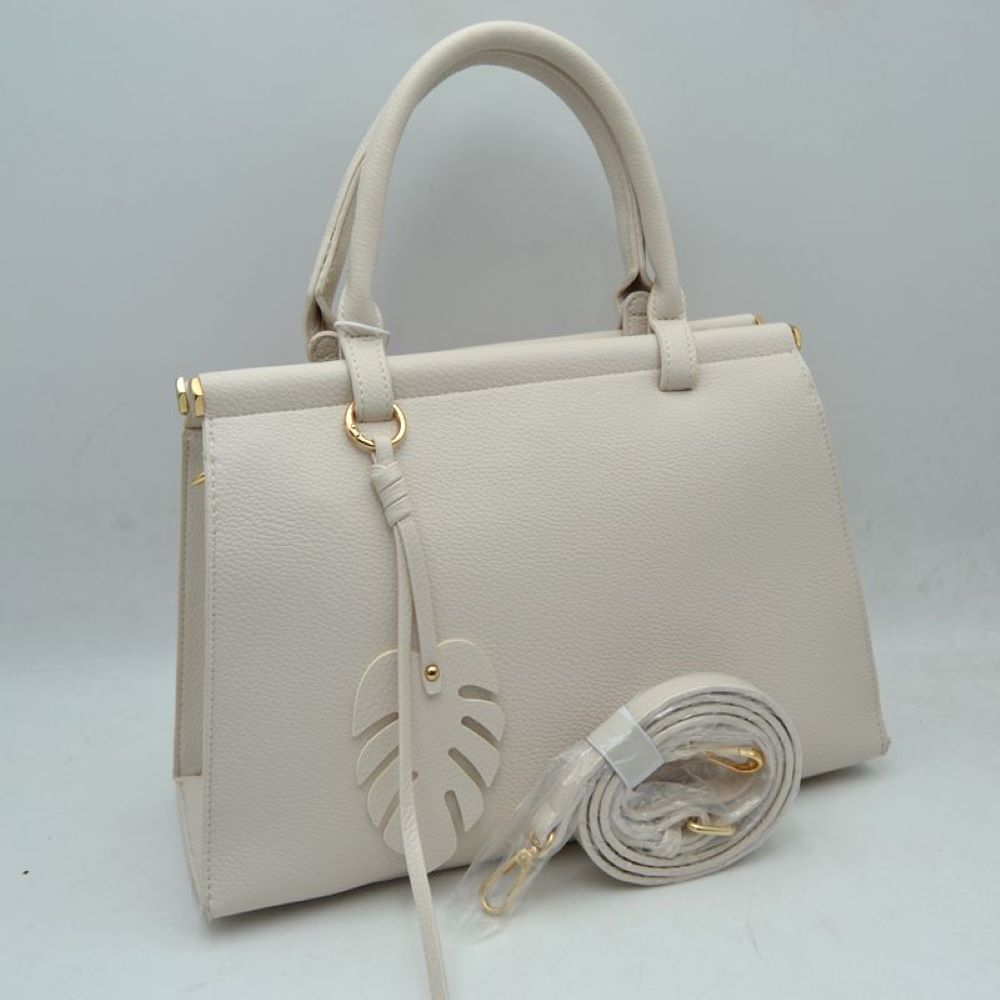 Ivory This stylish structured handbag is designed for everyday elegance and practicality. Crafted with a premium textured finish, it features a sleek top-handle design with gold-tone hardware accents for a luxurious touch. The spacious interior provides enough room for daily essentials like phone, wallet, cosmetics, and small accessories, making it perfect for both office and casual use. It also comes with a detachable and adjustable shoulder strap for versatile carrying options.