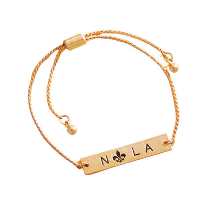 Jet Black Fleur de Lis Pointed Nola Message Pull Tie Cinch Bracelet, adds a sophisticated touch to any outfit. Crafted from an exquisite combination of materials, the bracelet features a Fleur de Lis pointed design with a Nola message pull tie cinch closure that makes it the perfect accessory for any occasion or as a lovely gift.