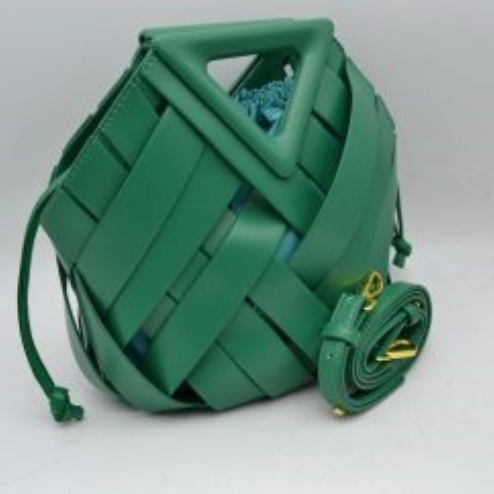 Kelly-green This structural bucket bag features a distinctive geometric design composed of overlapping wide woven straps that create an eye-catching pattern, making it a unique statement piece for everyday use. A rigid triangular cutout shape forms an integrated top handle, while an additional long, flat shoulder strap extends from the upper frame for comfortable over-the-shoulder carrying.