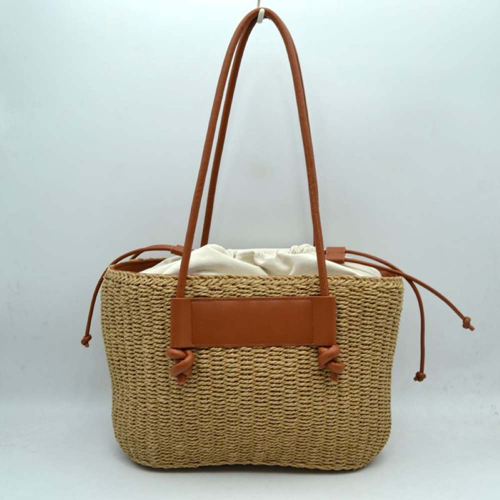 Brown Capture the ultimate warm-weather aesthetic with this gorgeous woven straw market tote. Perfectly blending a relaxed, organic texture with contemporary faux-leather accents, this shoulder bag is your ideal companion for beach getaways, local farmers' markets, or sunny vacation strolls.