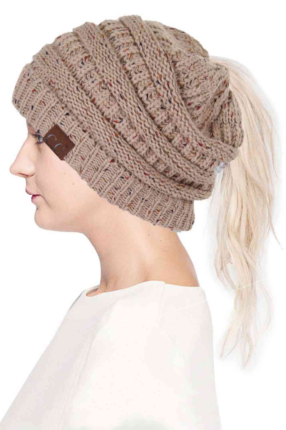 Latte The C.C Confetti Ponytail Messy Bun Beanie features a soft knit design with subtle confetti flecks for a fun, playful look. Designed with a convenient opening for ponytails or messy buns, it keeps you warm while allowing you to style your hair comfortably.