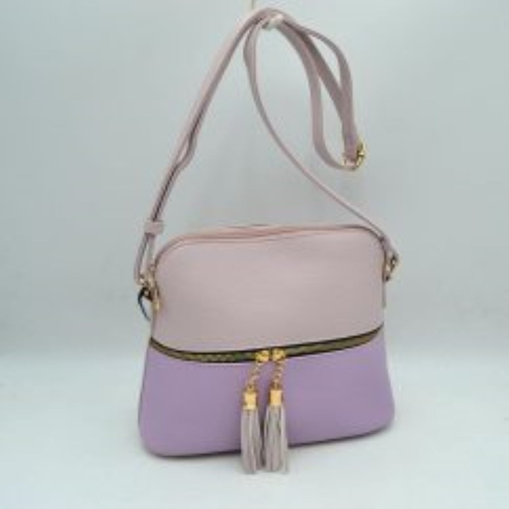 Lavender This everyday crossbody bag features a structured pebbled texture body with a distinct two-toned paneled design. Ideal for organized daily use, it showcases a prominent horizontal front zipper with dual gold-toned pulls, each adorned with a decorative hanging fringe tassel. The main storage compartment is paired with a matching long