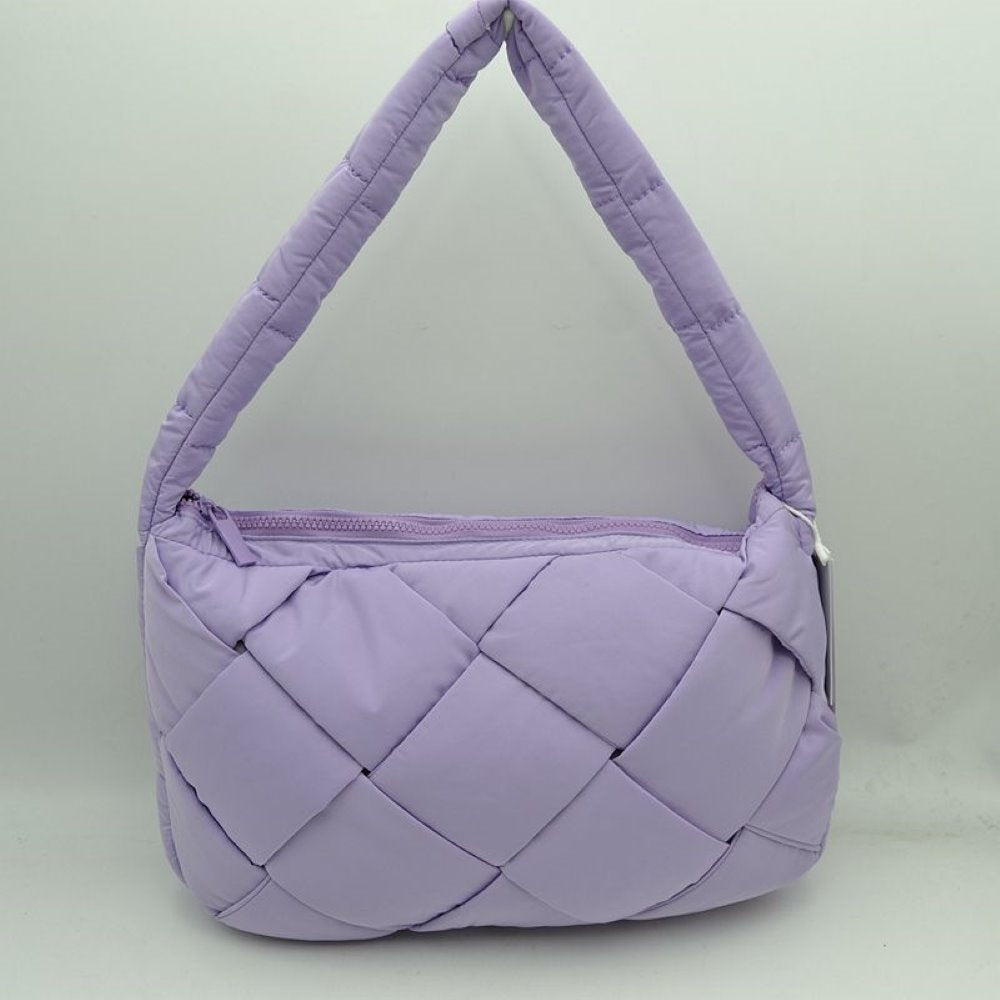 Lavender This padded shoulder bag features a distinctive interwoven design consisting of large, puffy square panels across the exterior. Ideal for effortless everyday use, it includes a wide, cushioned top strap integrated seamlessly into the sides for comfortable carrying. A matching top zipper closure runs along the upper edge to securely seal the main storage compartment while providing quick and easy access to essentials.