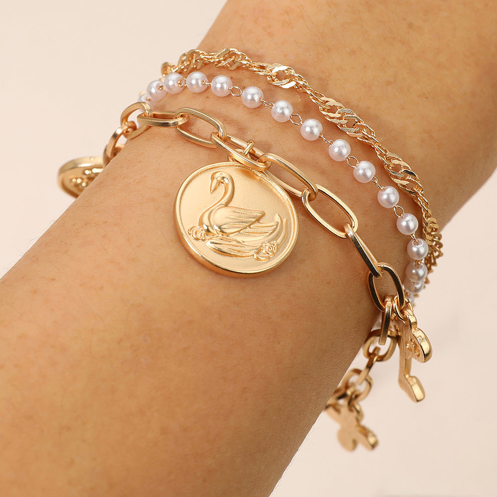Madeline Love Cream, Matte gold 3PCS - Flower Swan Embossed Medallion Key Cross Pearl Charm Station Multi Layered Bracelets