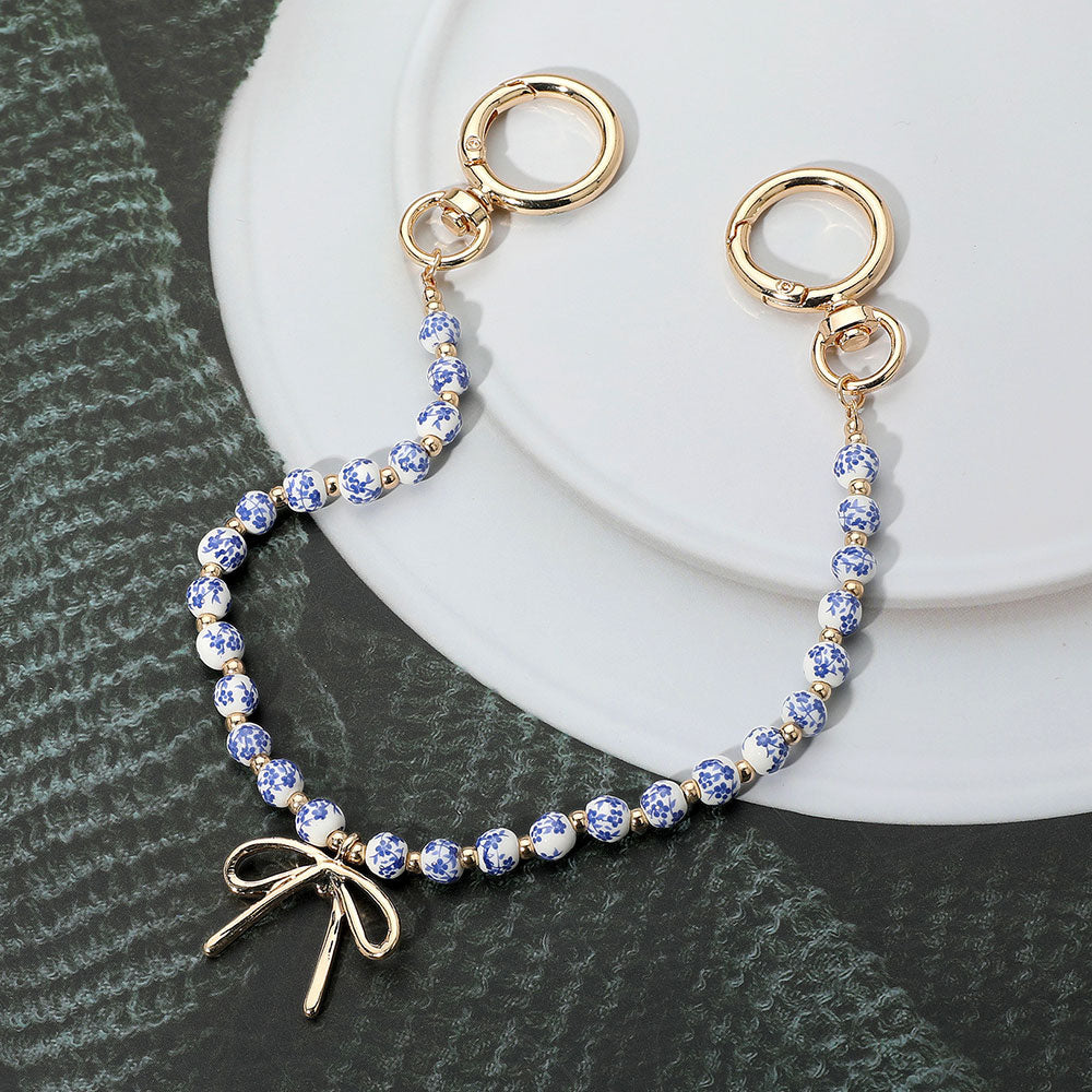 Madeline Love Blue, Gold Metal Bow Charm Pointed Floral Ceramic Ball Beaded Bag Charm - Bags & Wallets - desc