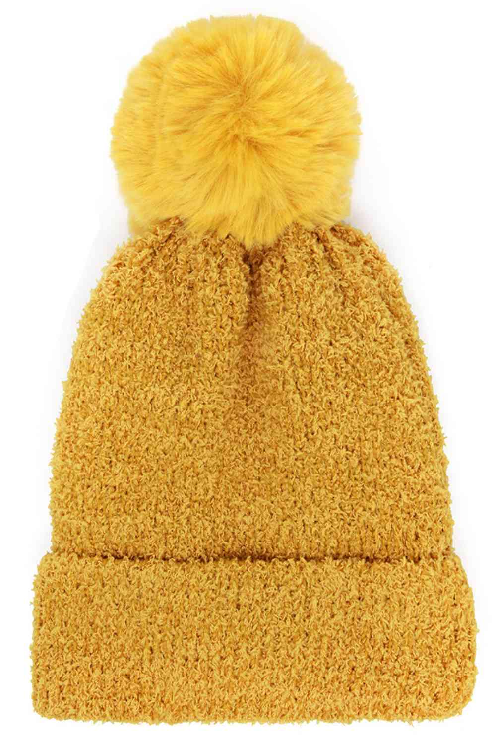 Mustard Stay warm and stylish with this cozy beanie crafted from a soft blend of 70% acrylic and 30% polyester. The fluffy texture and oversized pom pom add playful charm, while the ribbed brim ensures a secure, comfortable fit.