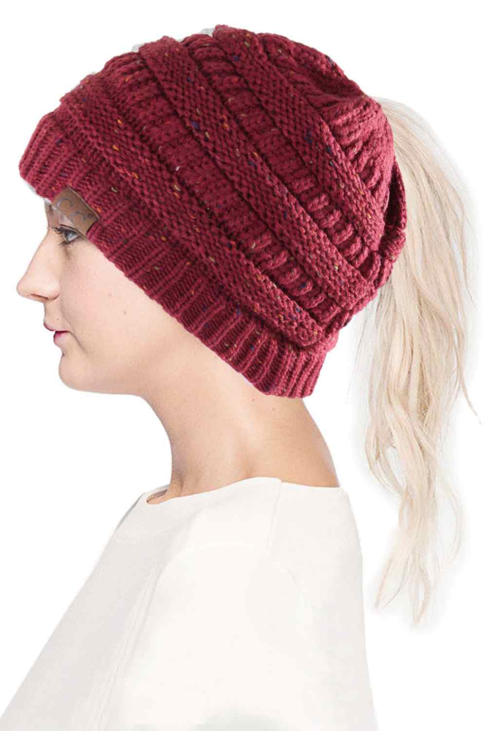 Maroon The C.C Confetti Ponytail Messy Bun Beanie features a soft knit design with subtle confetti flecks for a fun, playful look. Designed with a convenient opening for ponytails or messy buns, it keeps you warm while allowing you to style your hair comfortably.