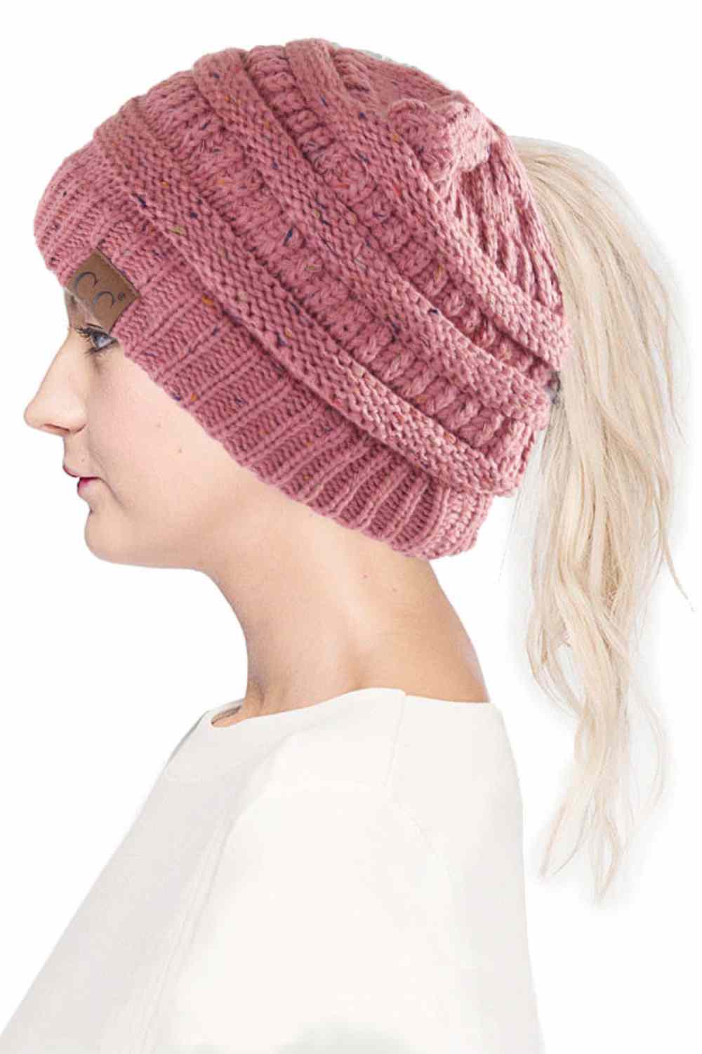 Mauve The C.C Confetti Ponytail Messy Bun Beanie features a soft knit design with subtle confetti flecks for a fun, playful look. Designed with a convenient opening for ponytails or messy buns, it keeps you warm while allowing you to style your hair comfortably.