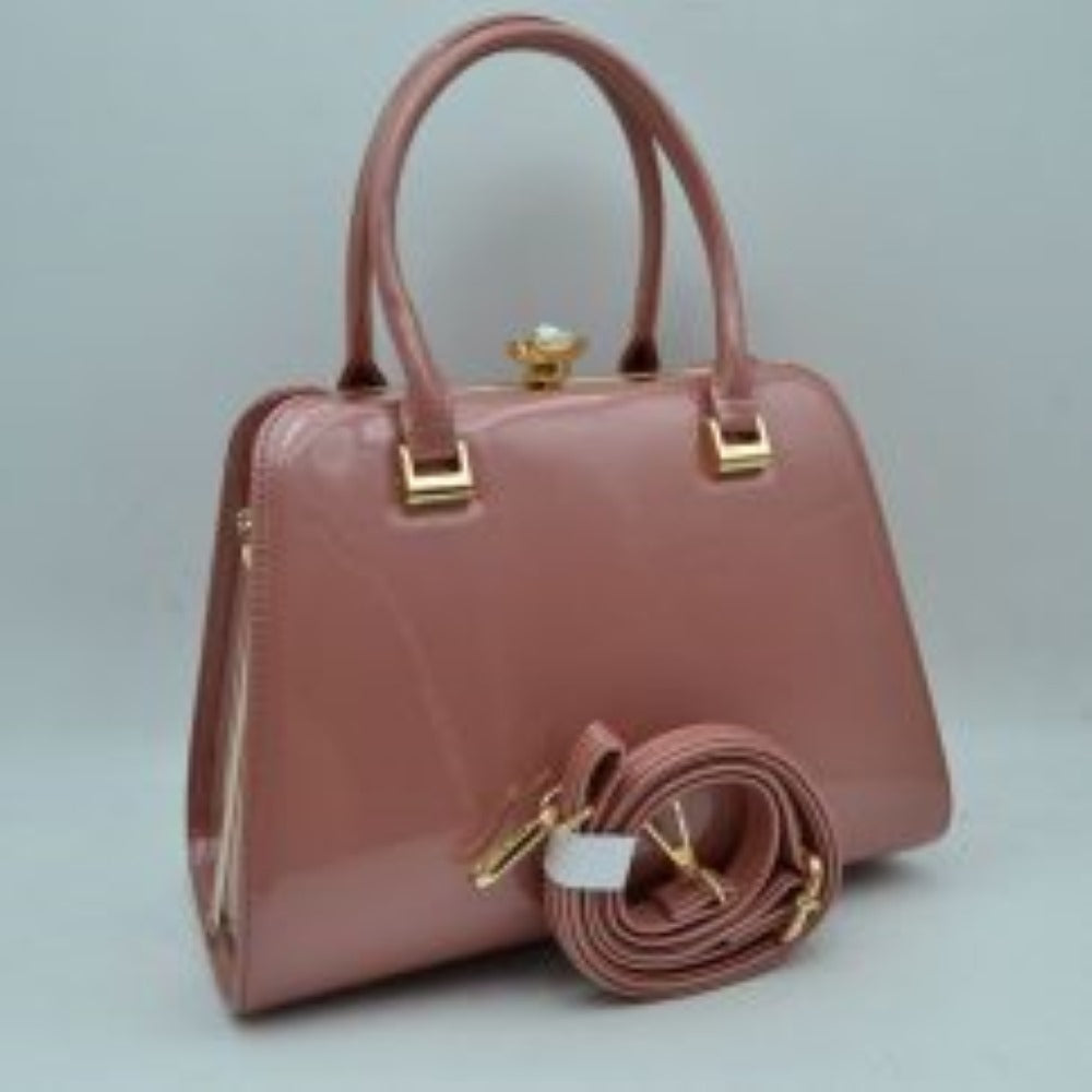 Mauve This sophisticated frame handbag features a high-shine patent finish and a structured trapezoidal silhouette, making it an elegant choice for evening or formal wear. Designed with a classic frame top closure, it is secured by a distinctive pearl-accented gold-tone twist lock. Dual rolled top handles attached via polished metallic hardware allow for stylish handheld carrying, while an included detachable shoulder strap with gold-tone clasps offers versatile hands-free shoulder options.
