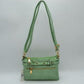 Mint This functional crossbody bag is designed for organized everyday use, featuring a textured exterior equipped with multiple secure storage compartments. The front panel includes a convenient horizontal zippered pocket accented with an oversized metallic zipper pull, situated beneath a decorative horizontal band detailed with metallic studs and loops.