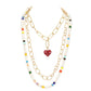 Multi Heart Pendant Accented Pearl Resin Beaded Triple Layered Necklace adds a touch of elegance and sophistication to any outfit. The heart pendant adds a sentimental touch, while the layered design creates a bold and eye-catching look. Made with high-quality materials, this necklace is both beautiful and durable.