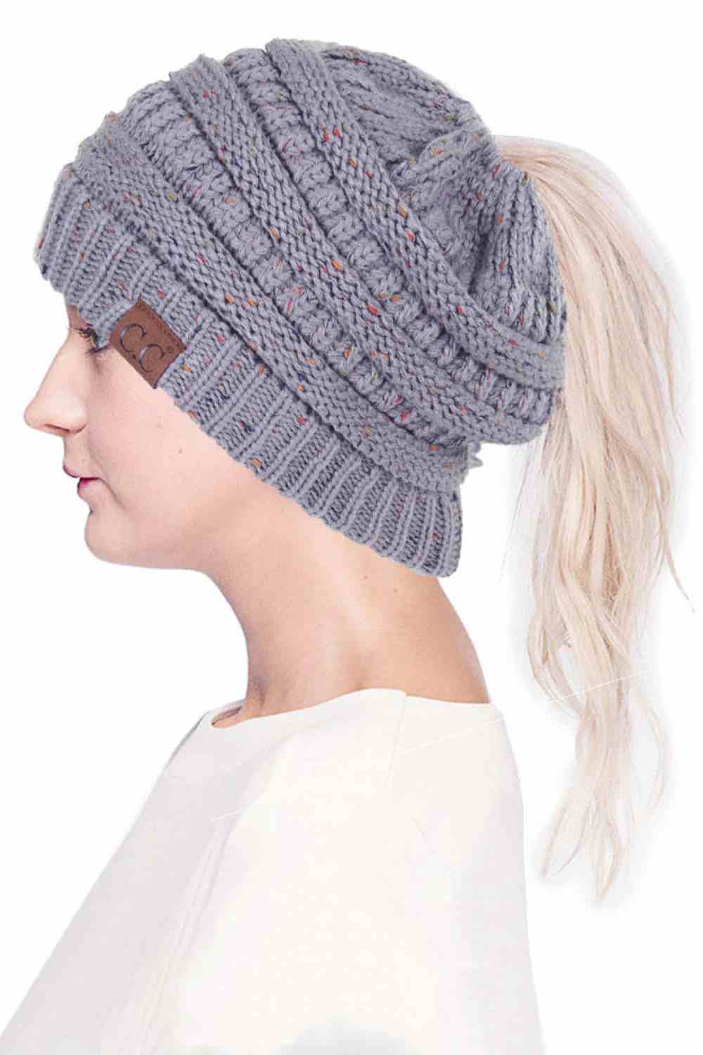 Natural Grey The C.C Confetti Ponytail Messy Bun Beanie features a soft knit design with subtle confetti flecks for a fun, playful look. Designed with a convenient opening for ponytails or messy buns, it keeps you warm while allowing you to style your hair comfortably.