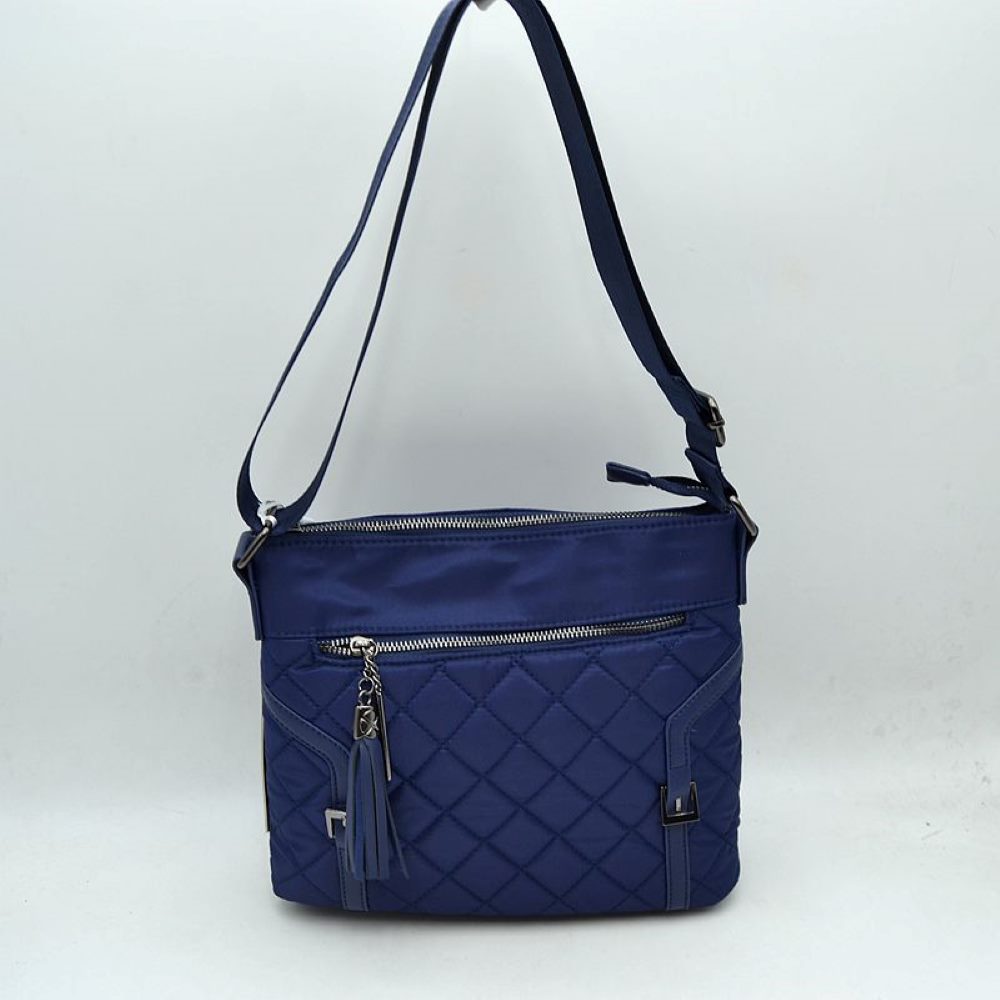 Navy Elevate your daily organization with this effortlessly chic crossbody bag. Designed with a striking mixed-media look, it combines a smooth nylon upper panel with a classic diamond-quilted body. The front is accented with a wide zipper compartment, a stylish hanging fringe tassel charm, and dual faux-leather vertical straps with polished metal buckles for a tailored finish.