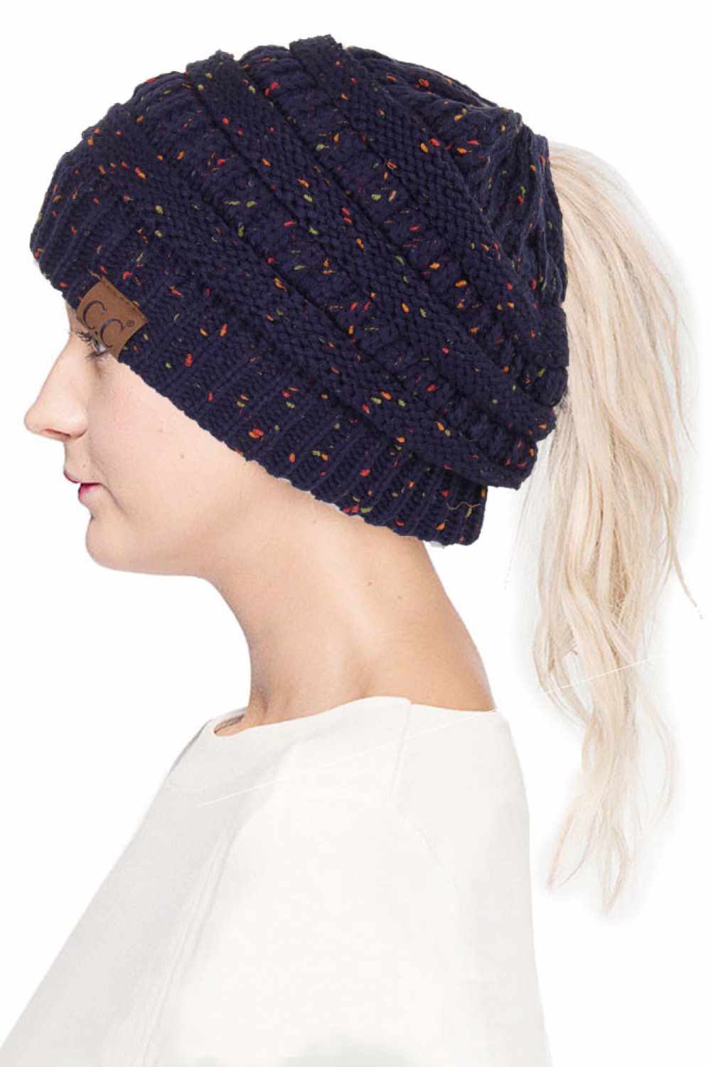 Navy The C.C Confetti Ponytail Messy Bun Beanie features a soft knit design with subtle confetti flecks for a fun, playful look. Designed with a convenient opening for ponytails or messy buns, it keeps you warm while allowing you to style your hair comfortably.