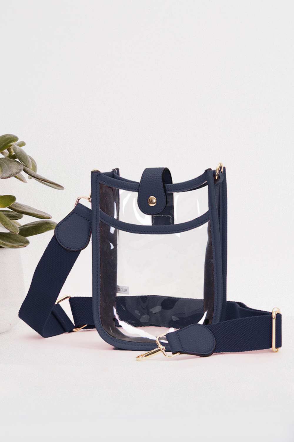 Navy Perfect for concert season and stadium events, this clear crossbody mini bag meets all venue security requirements while keeping your essentials within reach. Crafted from durable 100% PVC, it's easy to clean and built to last through countless outings. Compact yet functional at 8" x 5.8" x 2.3", the adjustable crossbody strap sits comfortably across your body, leaving your hands free. The transparent design lets you quickly locate your phone, keys, and small valuables at a glance.