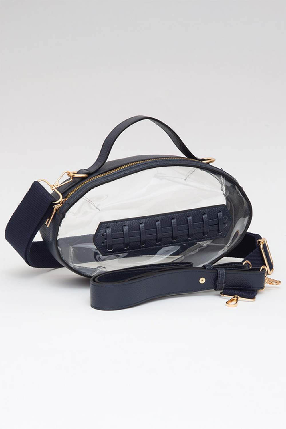 Navy Carry your essentials in style with this unique football-shaped transparent crossbody bag. Perfect for stadium events, concerts, and outdoor gatherings, the clear PVC design lets you see everything inside while meeting venue security requirements. Measuring 11" x 6" x 4", it offers practical storage without bulk. The adjustable crossbody strap keeps your hands free, making it ideal for busy days out. Durable 100% PVC construction ensures long-lasting wear through countless adventures.