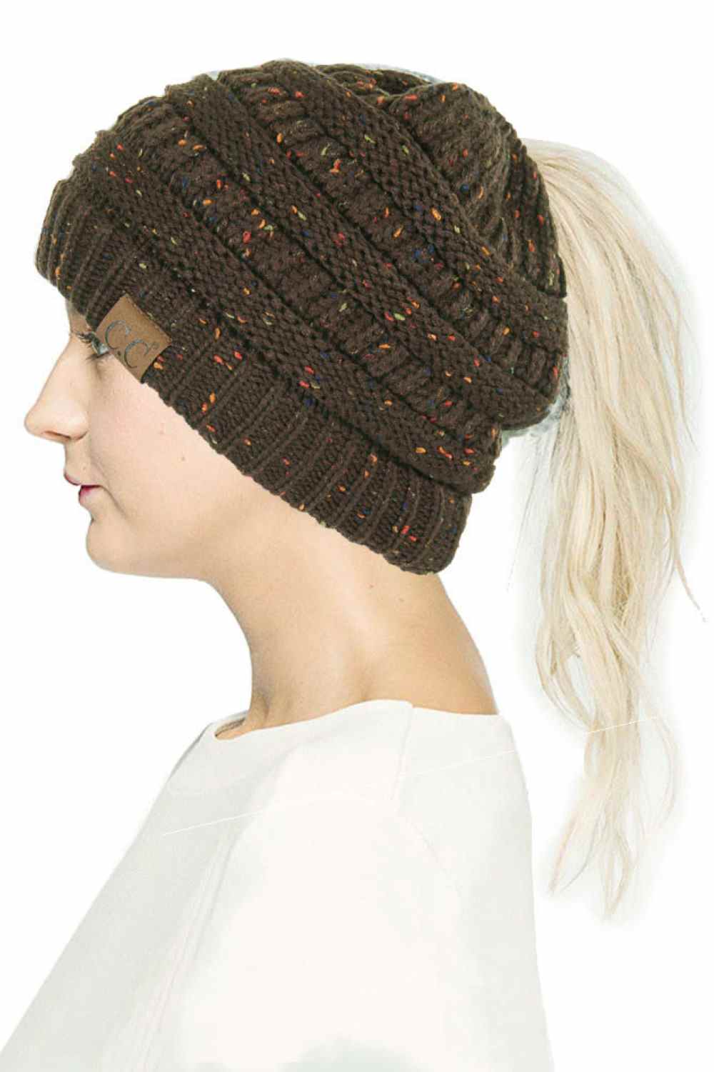 New Olive The C.C Confetti Ponytail Messy Bun Beanie features a soft knit design with subtle confetti flecks for a fun, playful look. Designed with a convenient opening for ponytails or messy buns, it keeps you warm while allowing you to style your hair comfortably.