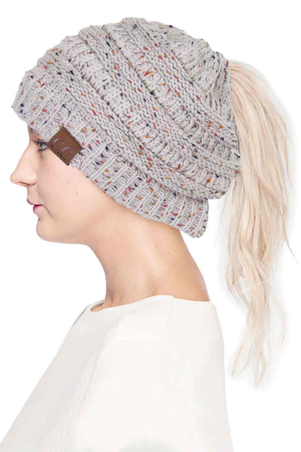 Oatmeal The C.C Confetti Ponytail Messy Bun Beanie features a soft knit design with subtle confetti flecks for a fun, playful look. Designed with a convenient opening for ponytails or messy buns, it keeps you warm while allowing you to style your hair comfortably.